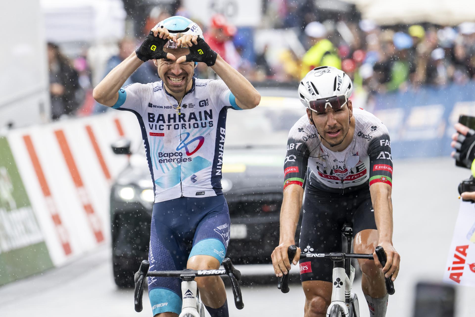 El corredor francés Lenny Martinez (I), del equipo Bahrain Victorius, celebra la victoria mientras se lamenta el portugués Joao Almeida, del UAE Team Emirates, en la penúltima etapa, la 'reina' de la cerrara, con 128,4 kilómetros entre Sion y final en alto en la estación Thyon 2.000. EFE/EPA/JEAN-CHRISTOPHE BOTT