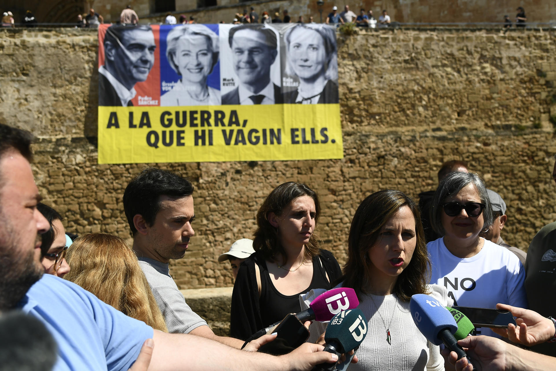 La secretaria general de Podemos, Ione Belarra, hace declaraciones con motivo de su visita a Palma, delante de la pancarta con el lema "A la guerra, que vayan ellos" frente a la catedral este viernes.EFE/ Miquel A. Borràs