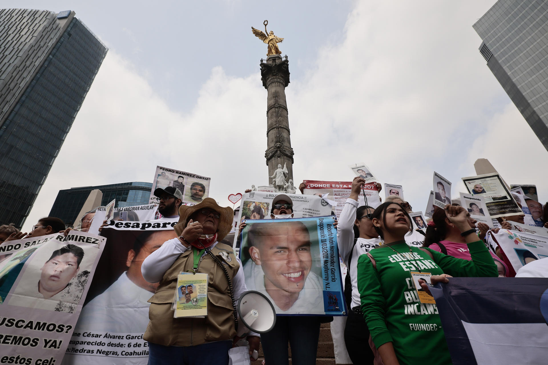Integrantes de colectivos de búsqueda de personas desaparecidas sostienen fotos en una marcha para exigir su localización este sábado, en Ciudad de México (México). EFE/ José Méndez