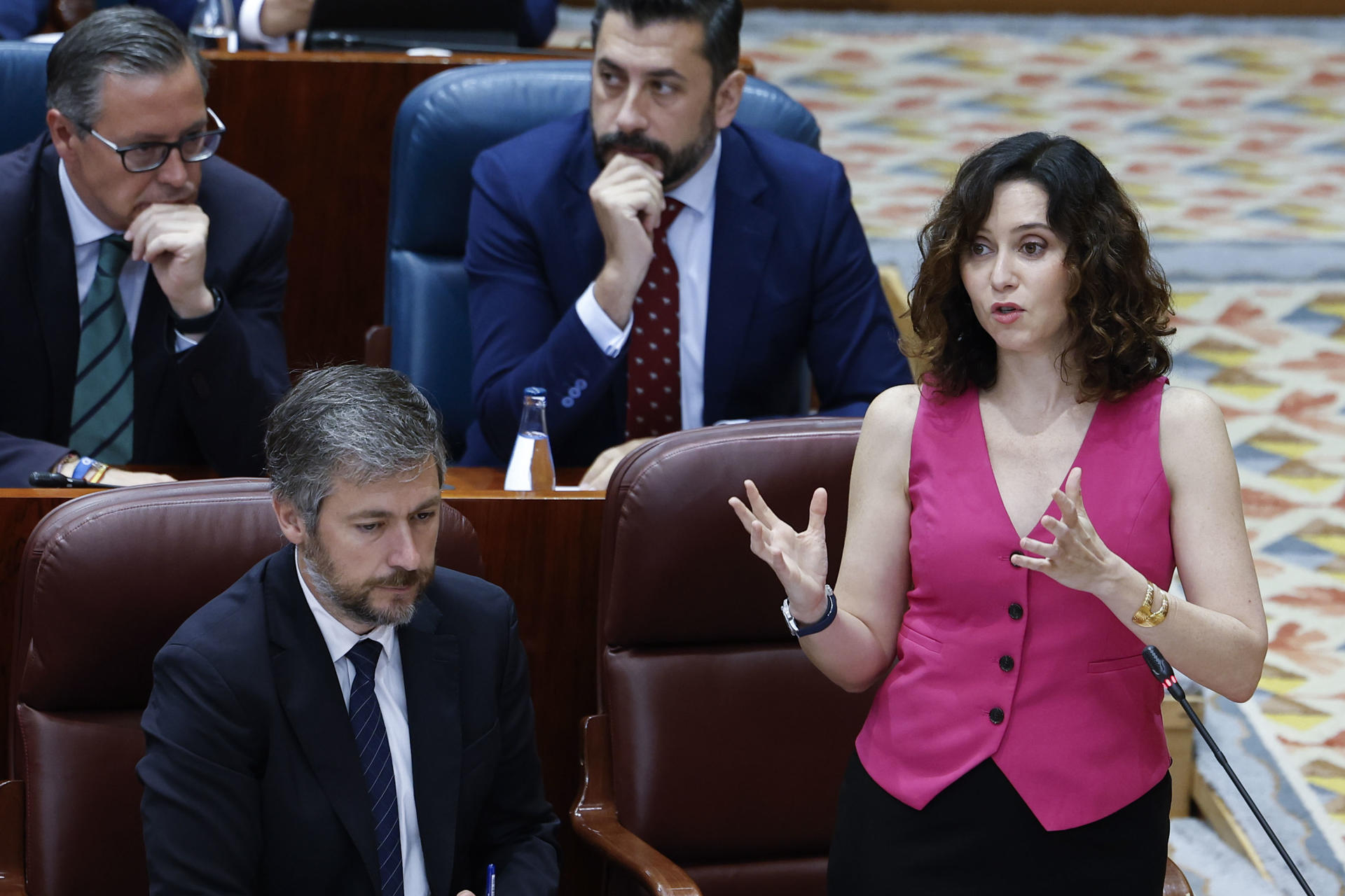 La presidenta de la Comunidad de Madrid, Isabel Díaz Ayuso (d), interviene durante el pleno en la Asamblea de Madrid, este jueves. EFE/ Chema Moya