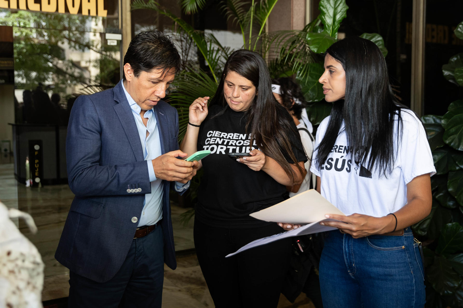 El segundo secretario de la Embajada de Colombia en Venezuela, John Rodríguez (i), habla con familiares durante una manifestación por la liberación de los "presos políticos" este lunes, en Caracas (Venezuela). EFE/ Ronald Peña R