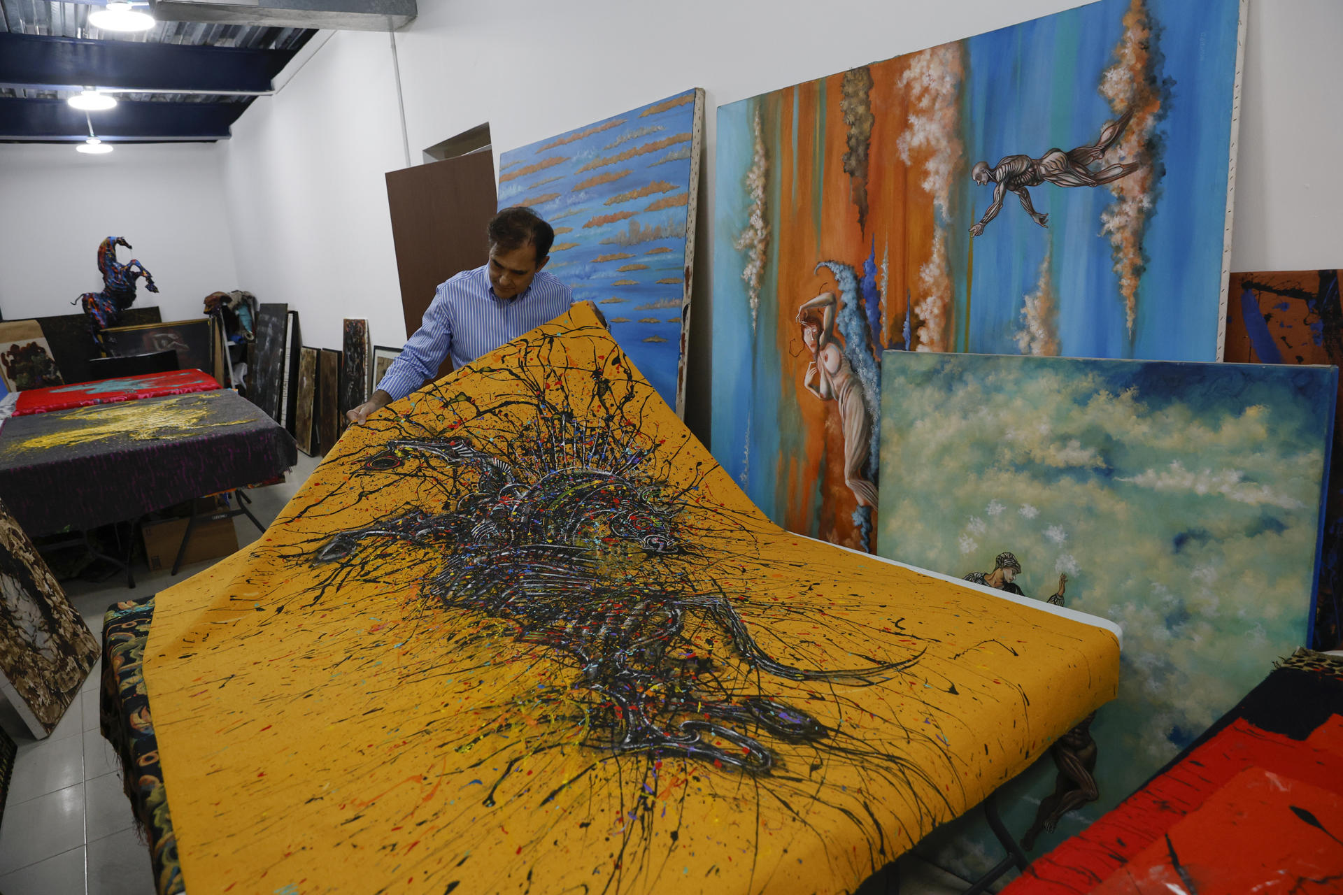 Fotografía del 9 de mayo de 2025 del artista panameño Eduardo Navarro mostrando una obra en su taller en Costa del Este, en Ciudad de Panamá (Panamá). EFE/ Bienvenido Velasco