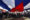 Personas sostienen una bandera de Cuba durante el desfile del Primero de Mayo este jueves, en la Habana (Cuba). EFE/ Ernesto Mastrascusa