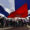 Personas sostienen una bandera de Cuba durante el desfile del Primero de Mayo este jueves, en la Habana (Cuba). EFE/ Ernesto Mastrascusa