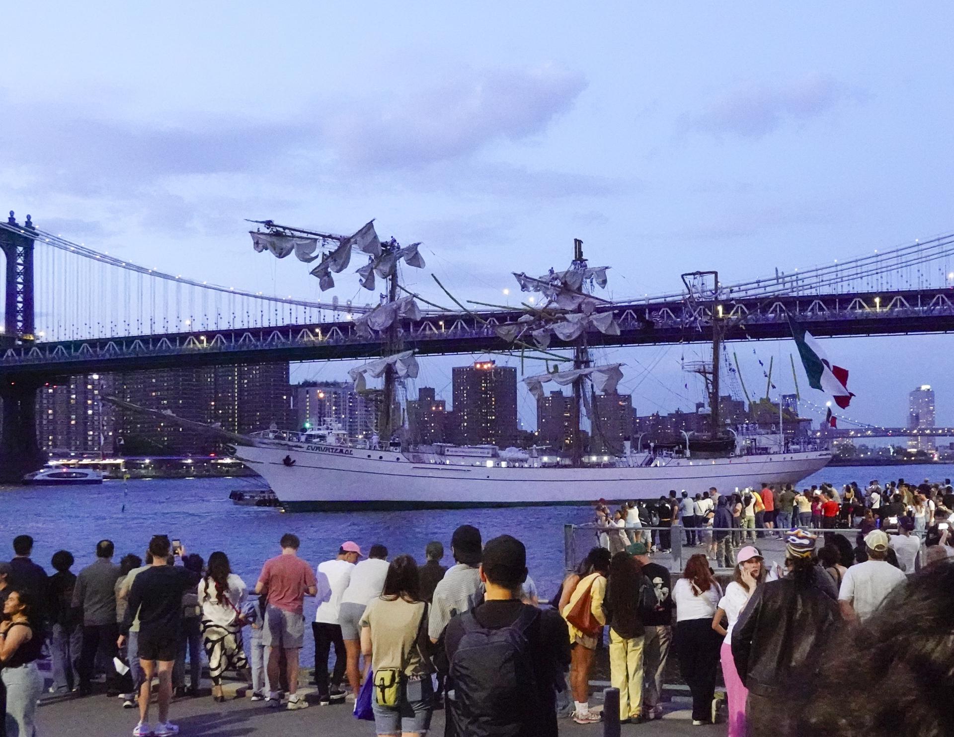 La gente mira al Cuauhtémoc, un buque escuela de la Armada mexicana, en el East River después de que el barco chocara contra el puente de Brooklyn, en Nueva York, el 17 de mayo de 2025. EFE/EPA/PORTER BINKS