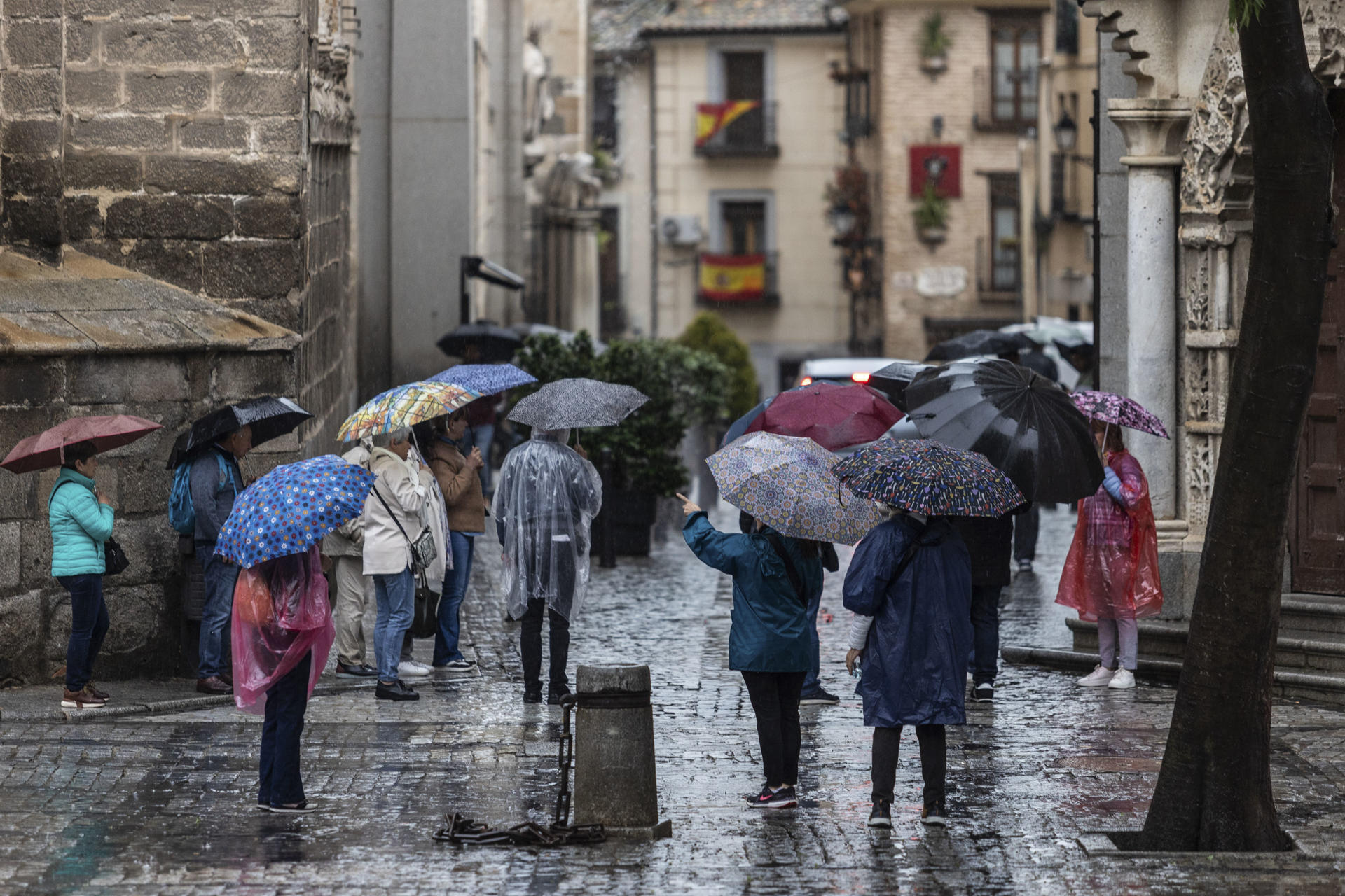 Varias personas se protegen de la lluvia con un paraguas mientras pasean por Toledo, este viernes. El Gobierno de Castilla-La Mancha ha activado, a las 9:25 horas de este viernes, el Plan Específico ante el Riesgo por fenómenos Meteorológicos Adversos (Meteocam), en fase de alerta, como consecuencia de los avisos de nivel amarillo y naranja emitidos por la Agencia Estatal de Meteorología (Aemet) por lluvias y tormentas que pueden venir acompañadas de granizo. EFE/ Ángeles Visdómine