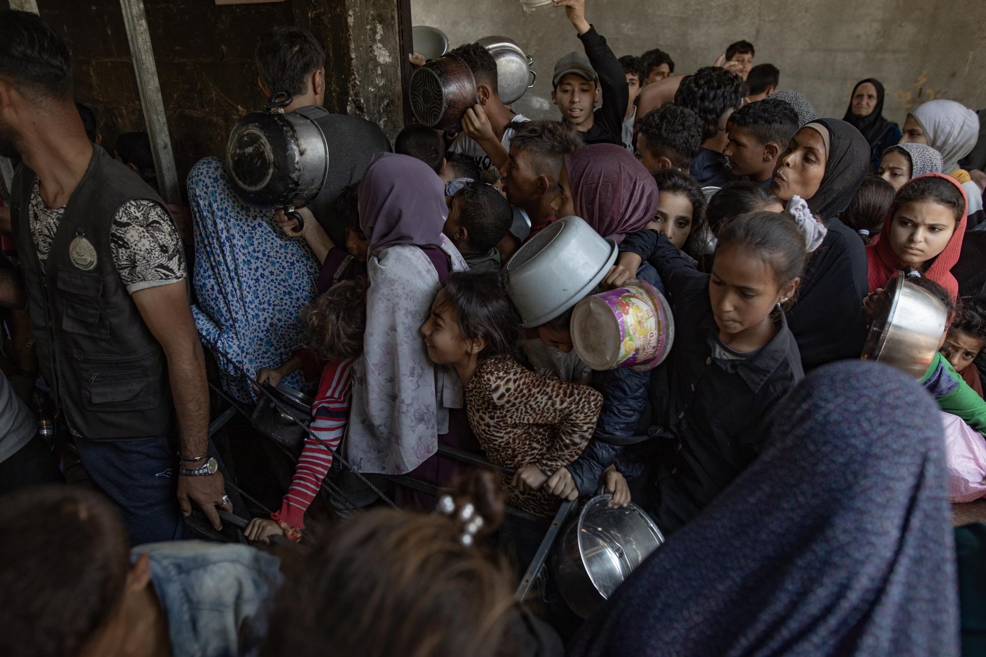 Cientos de palestinos se amontonan frente al Comedor Social Sokar en la Ciudad de Gaza para conseguir raciones de comida. EFE/ Haitham Imad