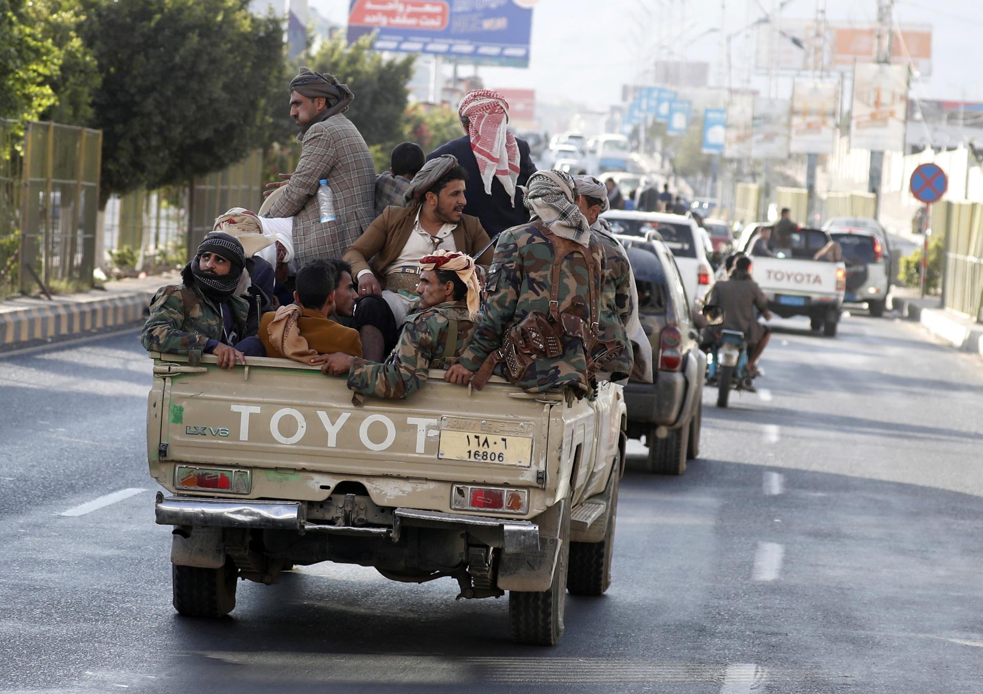 Simpatizantes hutíes montan en la parte trasera de un vehículo militar tipo pick-up que circula por una calle de Saná, Yemen, en una fotografía de archivo. EFE/YAHYA ARHAB