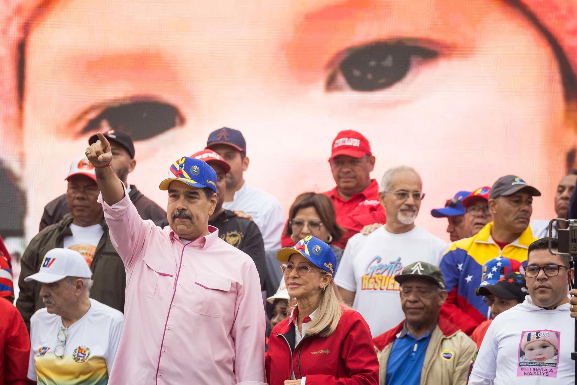 El presidente de Venezuela, Nicolas Maduro (i), saluda junto a la primera dama, Cilia Flores, este jueves, en una manifestación por Día Internacional del Trabajador en Caracas (Venezuela). EFE/ Miguel Gutiérrez