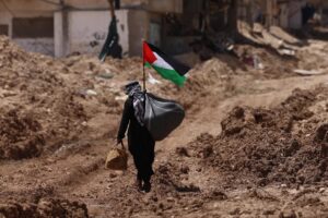Fotografía de un hombre palestino que camina frente a la entrada principal del campo de refugiados de Tulkarem en la ciudad cisjordana de Tulkarem, el 19 de mayo de 2025. EFE/EPA/ALAA BADARNEH