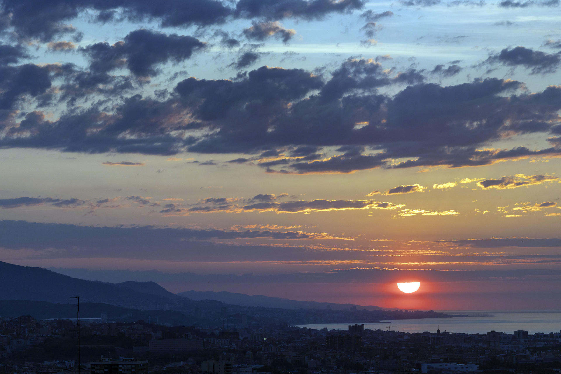 Aspecto de la salida del sol desde Barcelona en una mañana soleada con intervalos de nubes finas cruzando de oeste a este en Cataluña, este miércoles. EFE/Marta Pérez