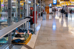 Una persona duerme en el aeropuerto Adolfo Suárez Madrid-Barajas. EFE/Fernando Villar