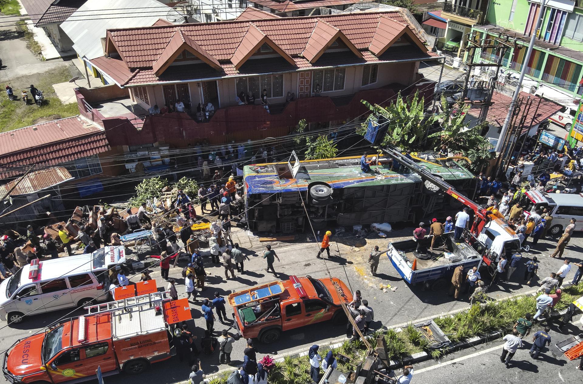 PADANG PANJANG (Indonesia), 06/05/2025.- A handout photo made available by the Indonesia's Search and Rescue Agency (BASARNAS) shows rescuers working on an overturned bus after a crash in Padang Panjang, West Sumatra, Indonesia, 06 May 2025. At least 12 people were killed and dozens injured following the accident, according to the police. EFE/EPA/BASARNAS HANDOUT HANDOUT EDITORIAL USE ONLY/NO SALES