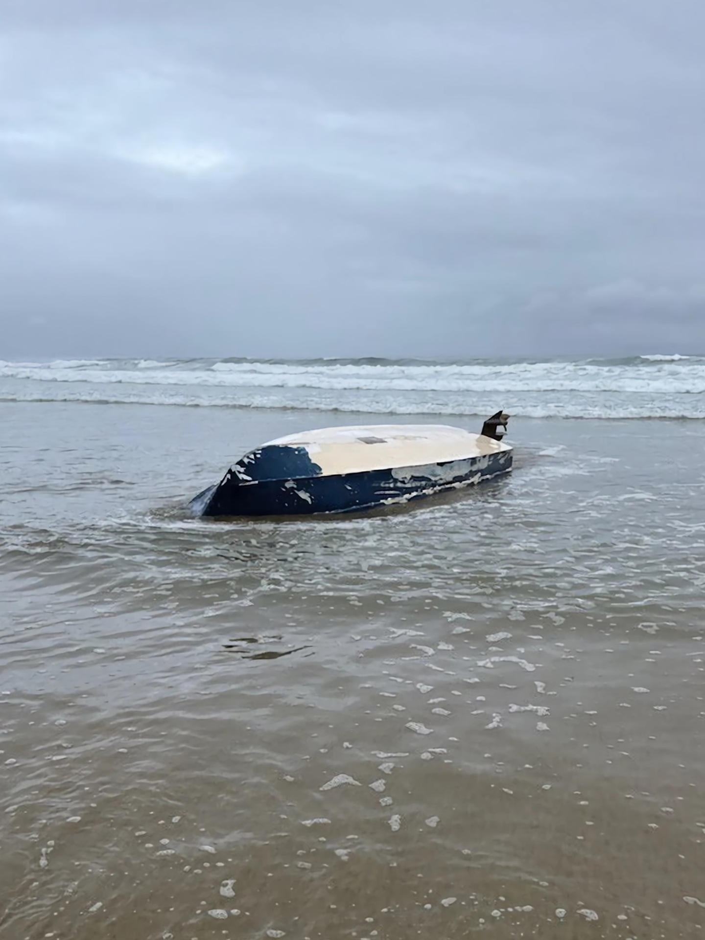 Fotografía divulgada por la Guardia Costera de los Estados Unidos (USCG) del Norte de California donde se muestra la embarcación tipo panga tirada en la orilla de la playa, después de naufragar en las aguas de la Costa de Del Mar, en el condado de San Diego, cerca a la frontera de California con México. EFE/USCGNorCal