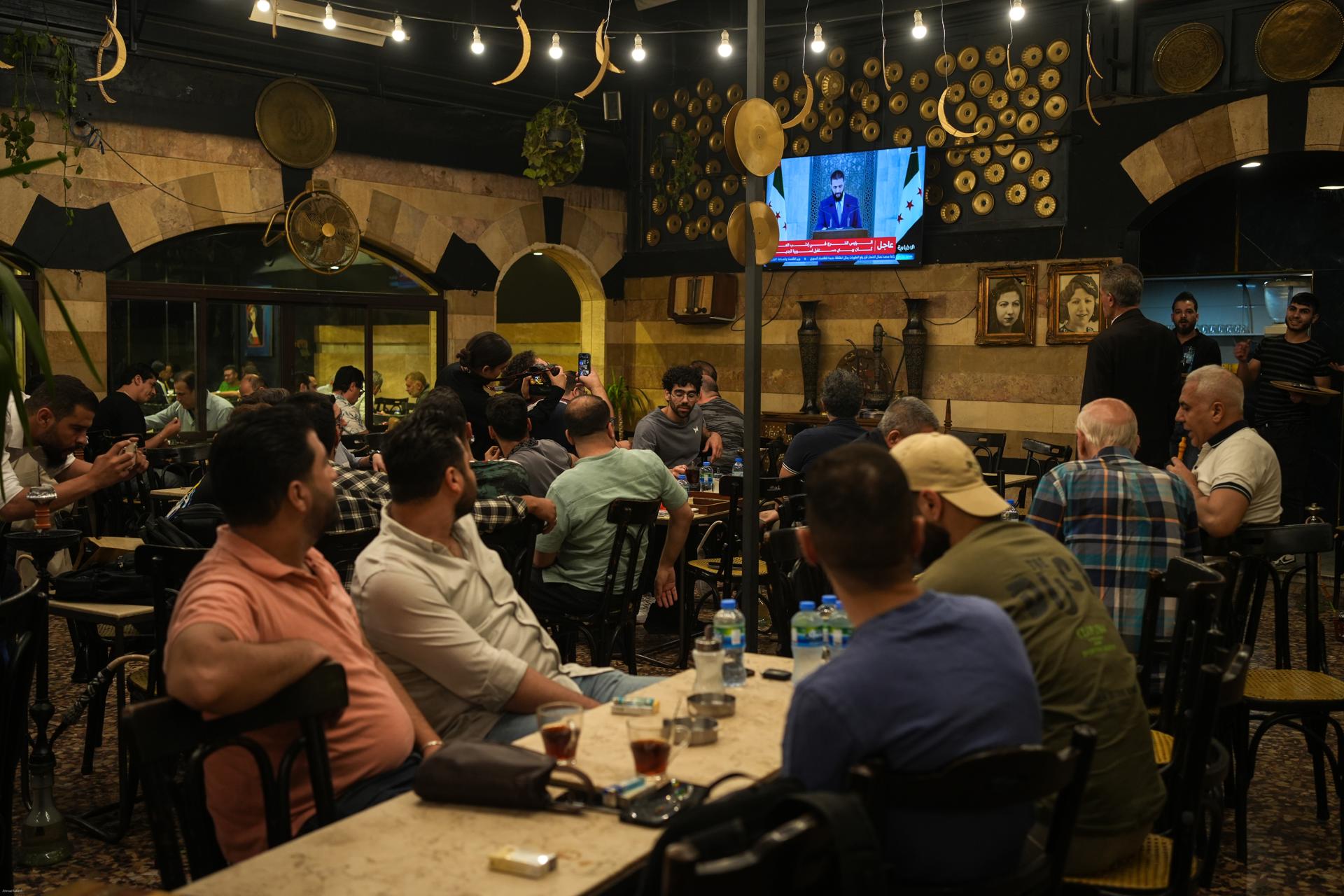 Los sirios ven un discurso del presidente sirio Ahmad al-Sharaa, después de la decisión de Trump de levantar las sanciones a Siria, en el café Al-Rawda en el centro de Damasco, Siria, 14 de mayo de 2025. EFE/AHMAD FALLAHA