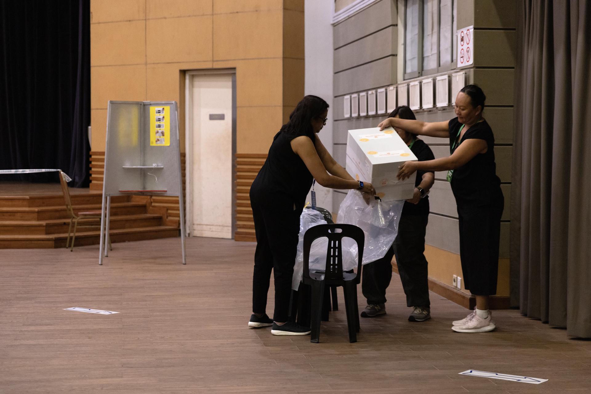 Un grupo de oficiales sella las urnas en un centro de votación en Singapur el 3 de mayo de 2025. EFE/EPA/HOW HWEE YOUNG