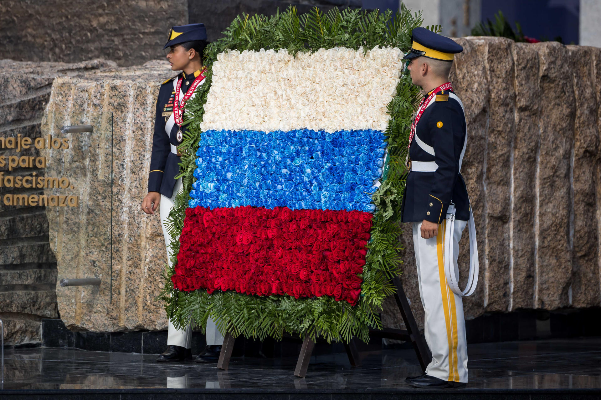 Dos militares venezolanos sostienen un arreglo floral que forma la bandera de Rusia durante la inauguración de la plaza de La Victoria este martes, en conmemoración de los 80 años del triunfo del Ejército Rojo sobre la Alemania Nazi, en Caracas (Venezuela). EFE/ Miguel Gutiérrez