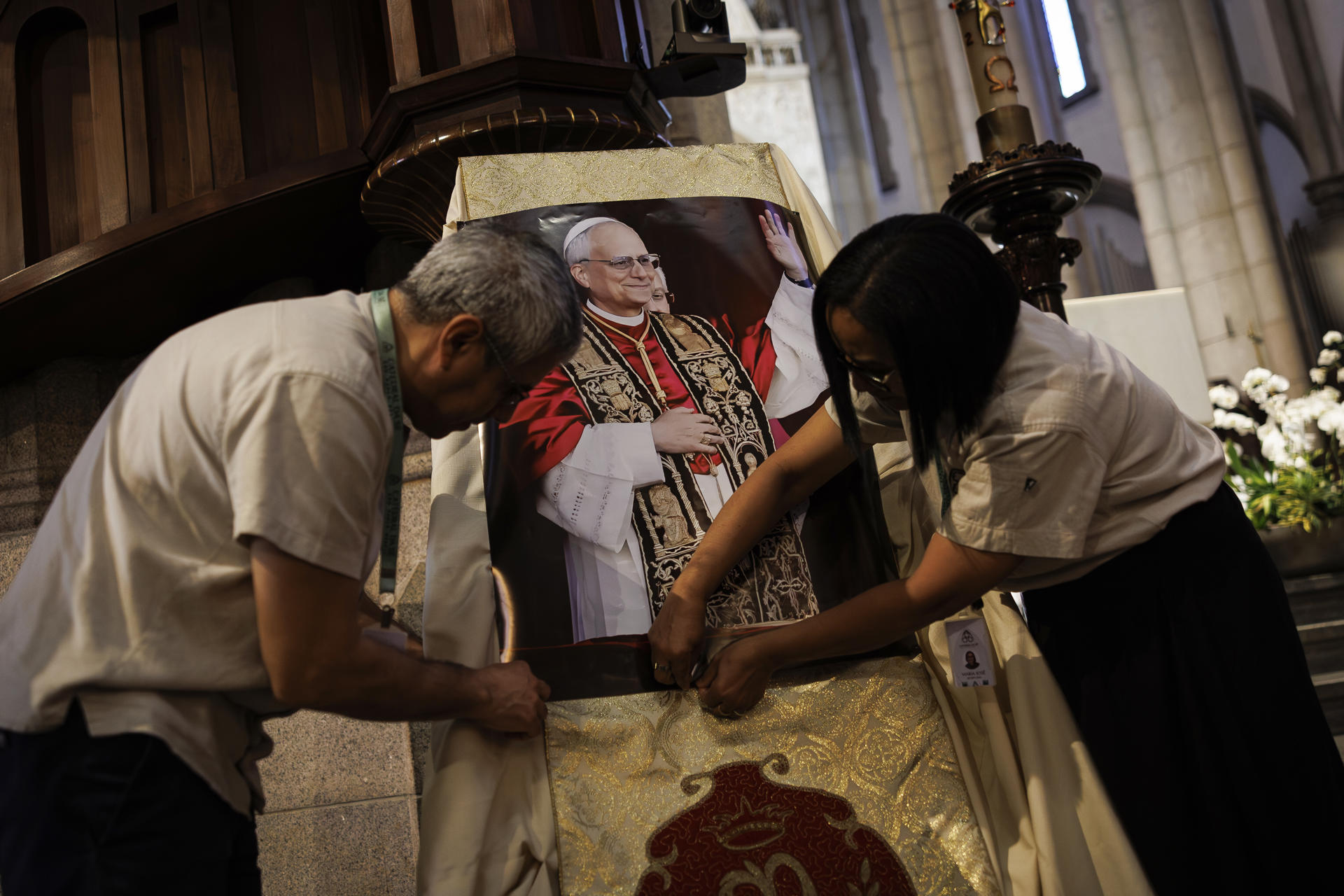 Personas sostienen la imagen del papa León XIV durante una misa en honor al nuevo pontífice este viernes, en La catedral de la ciudad de São Paulo (Brasil). EFE/ Isaac Fontana