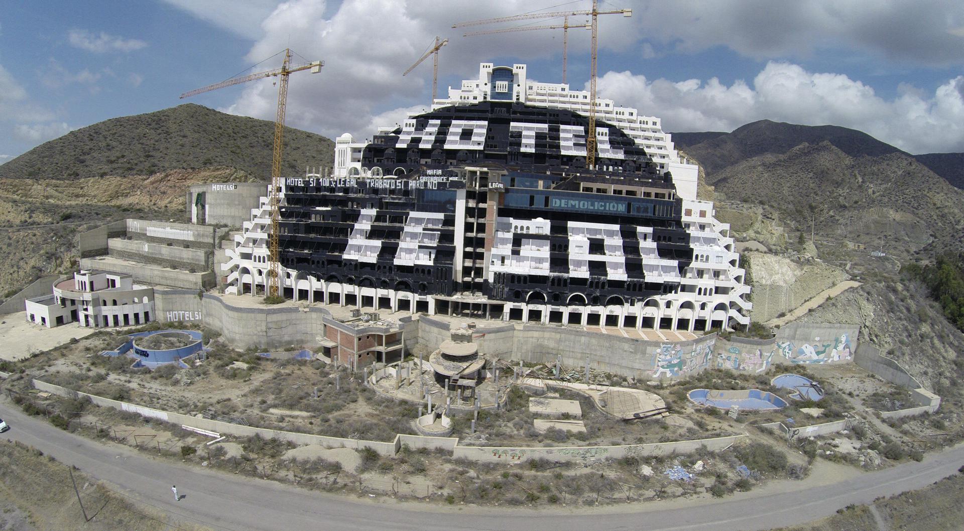 En la imagen de archivo, una gran pintada en blanco con la leyenda "Hotel sí cien por cien legal", "Trabajo sí paro no" sobre el fondo negro que a su vez pintaron los miembros de Greenpeace solicitando su derribo, en el hotel de El Algarrobico. EFE/Carlos Barba