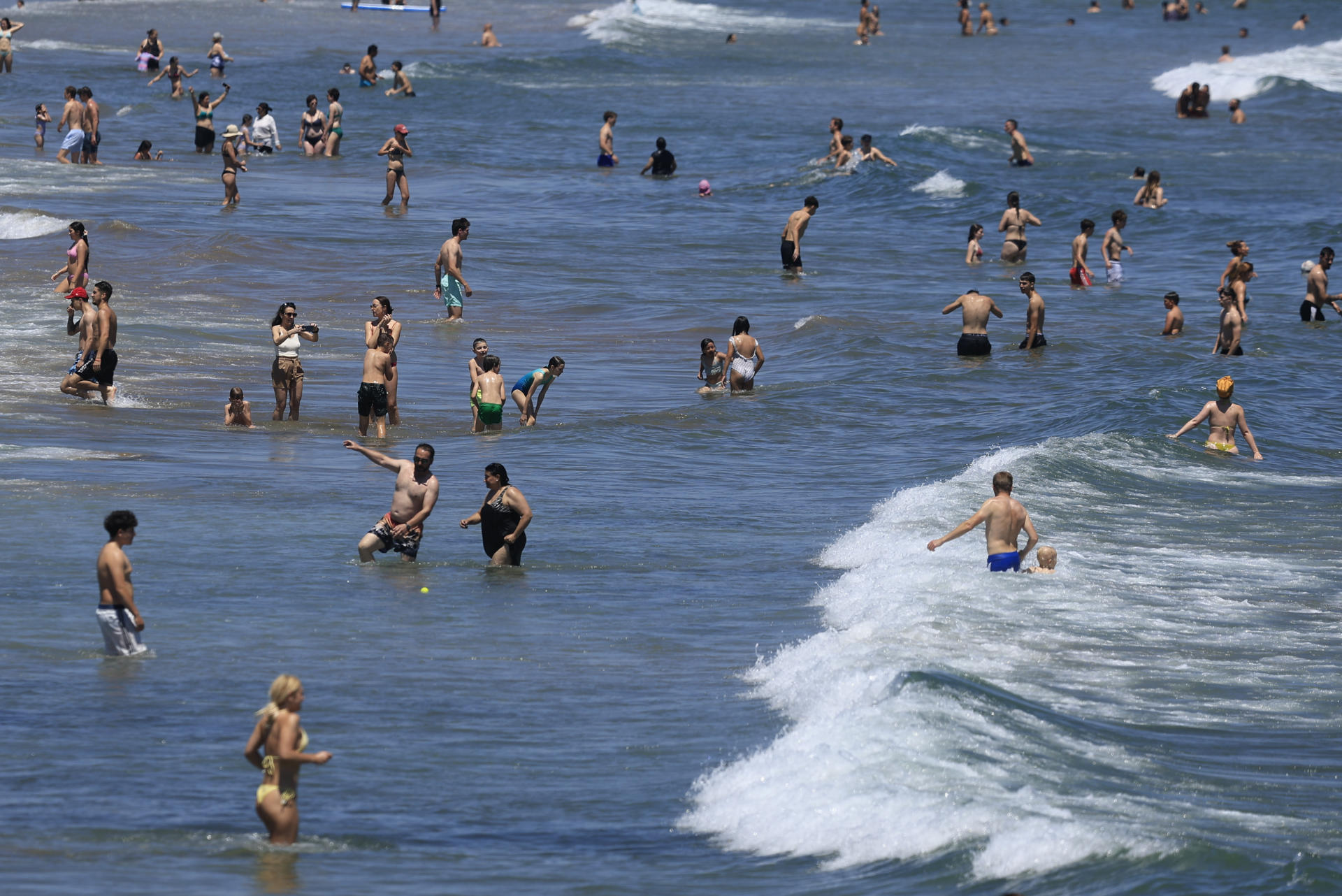 Cientos de personas se han acercado a la playa de la Malvarrosa de Valencia, para disfrutar de las altas temperaturas registradas este domingo. EFE/ Kai Forsterling