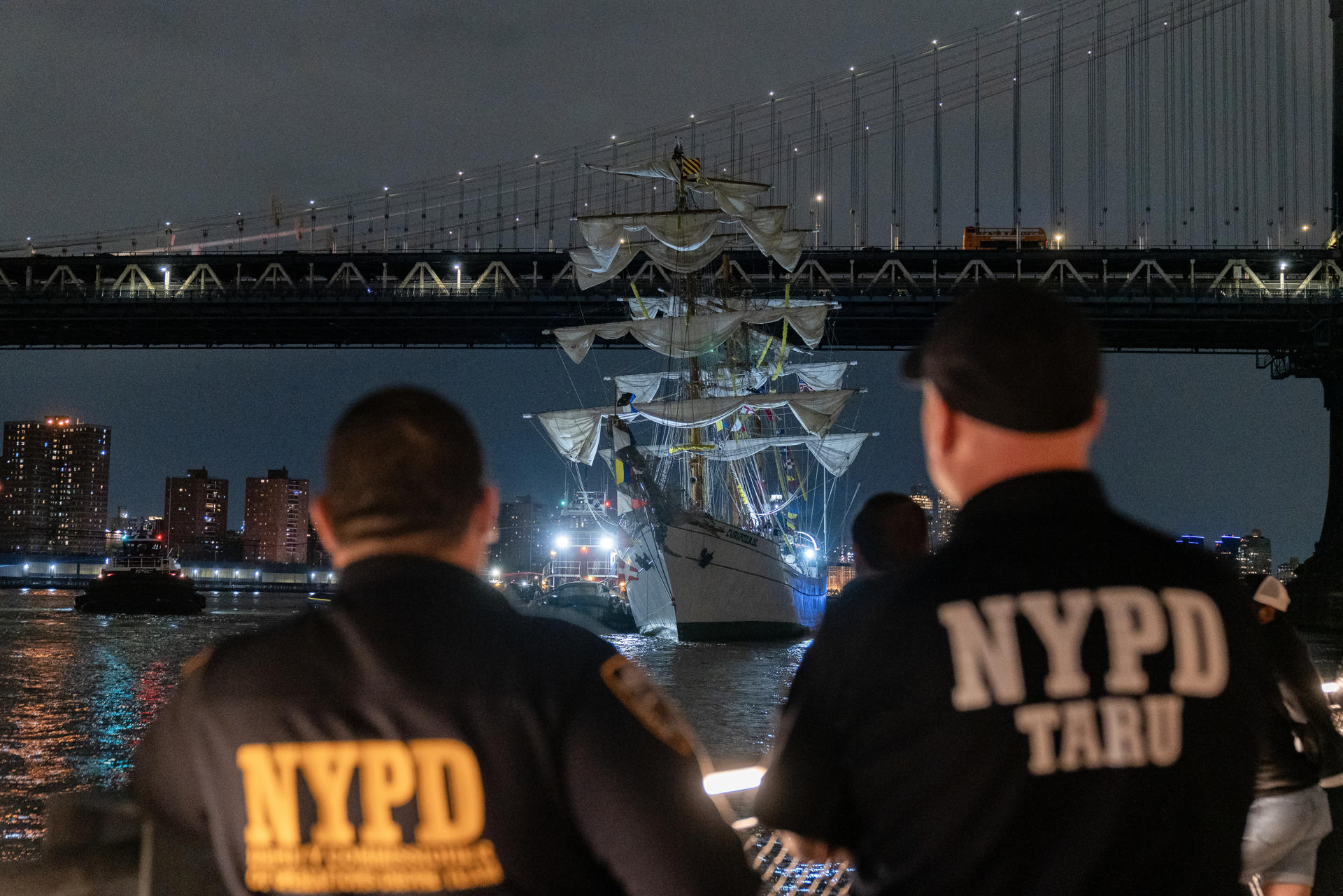 Integrantes del departamento de Policía de Nueva York observan el buque escuela mexicano Cuauhtémoc junto al puente de Brooklyn este sábado, en Nueva York (EE.UU.). EFE/ Angel Colmenares