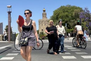 Varias personas caminan cerca de la Torre del Oro de Sevilla, este miércoles con alta temperaturas. EFE/Carlos Rivera