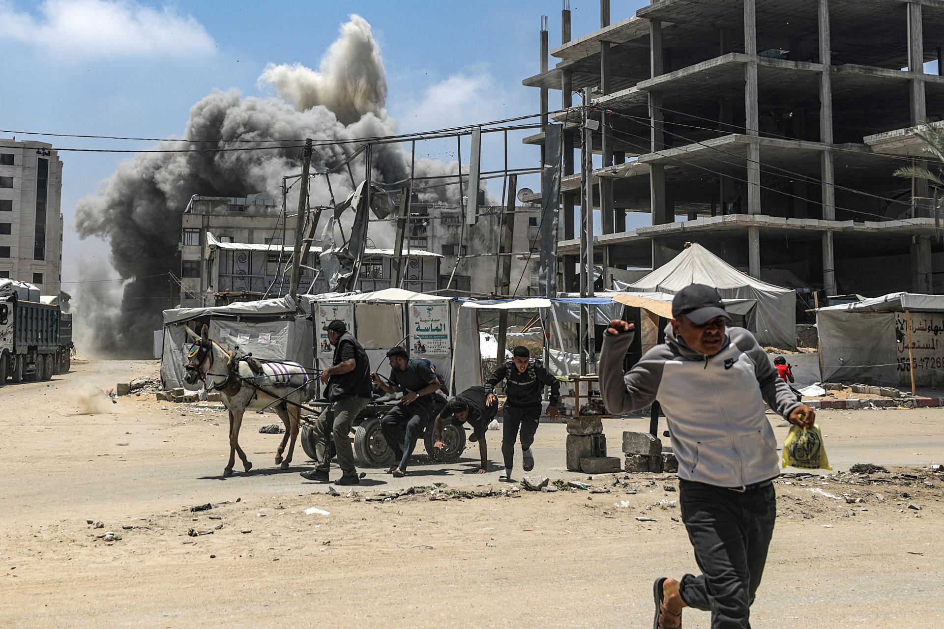 Un hombre palestino corre para cubrirse mientras se eleva humo tras un ataque aéreo israelí al oeste de la ciudad de Gaza, en la Franja de Gaza, el 23 de mayo de 2025. Más de 53.700 palestinos han muerto en la Franja de Gaza, según el Ministerio de Salud palestino, desde que Israel lanzó una campaña militar en la franja en respuesta a un ataque transfronterizo liderado por el grupo militante palestino Hamás el 7 de octubre de 2023, en el que murieron unos 1.200 israelíes y más de 250 fueron tomados como rehenes. EFE/EPA/MOHAMMED SABER