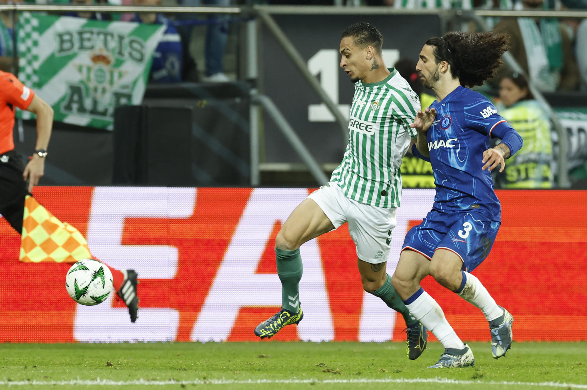 El delantero brasileño del Betis, Antony (i), disputa el balón ante el defensa español del Chelsea, Marc Cucurella, durante el encuentro correspondiente a la final de la Liga de Conferencia que disputan hoy miércoles Chelsea y Betis en el Tarczynski Arena de Breslávia. EFE / Julio Muñoz.