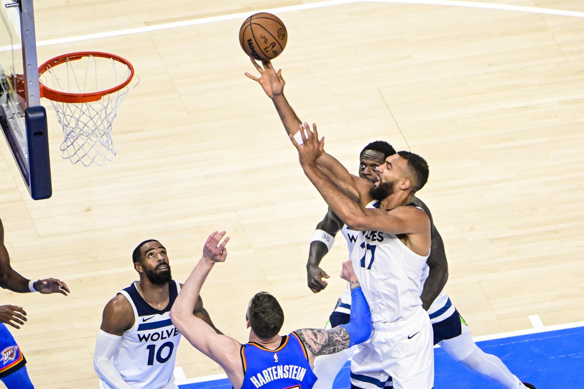 El pívot de los Minnesota Timberwolves, Rudy Gobert (D), lanza el balón a canasta durante el partido que ganó este jueves Thunder por 118-103 y que ha ampliado a 2-0 la ventaja de Oklahoma City Thunder en las finales del Oeste. EFE/EPA/GERALD LEONG.