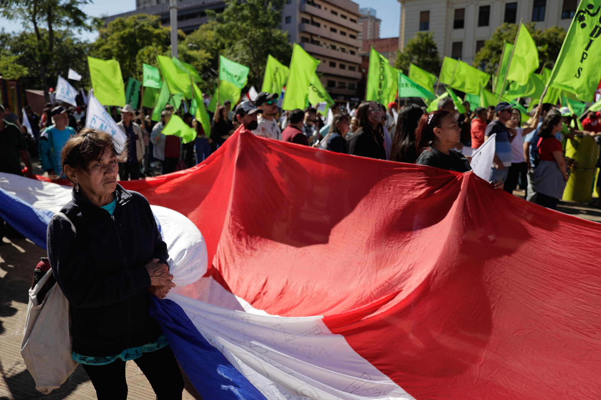 Una persona sostiene una bandera durante la manifestación en conmemoración del Día Internacional de los Trabajadores este 1 de mayo de 2025, en Asunción (Paraguay). EFE/ Juan Pablo Pino