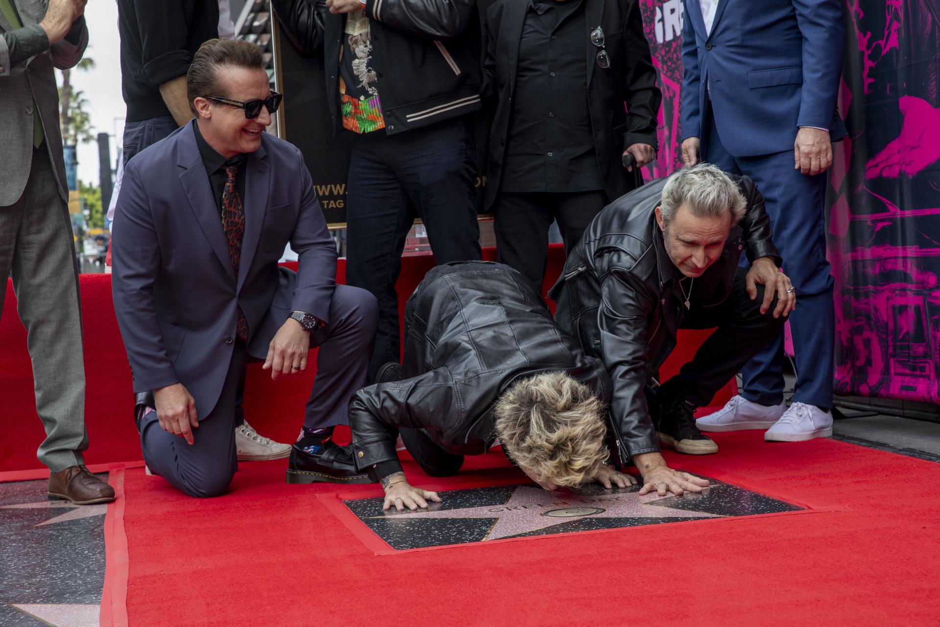 Los miembros de Green Day (de izq. a der.) Tre Cool, Billie Joe Armstrong y Mike Dirnt posan con su estrella durante la ceremonia de entrega de estrellas en el Paseo de la Fama de Hollywood en honor a Green Day en Los Ángeles, California, EE. UU., el 1 de mayo de 2025. EFE/EPA/JILL CONNELLY