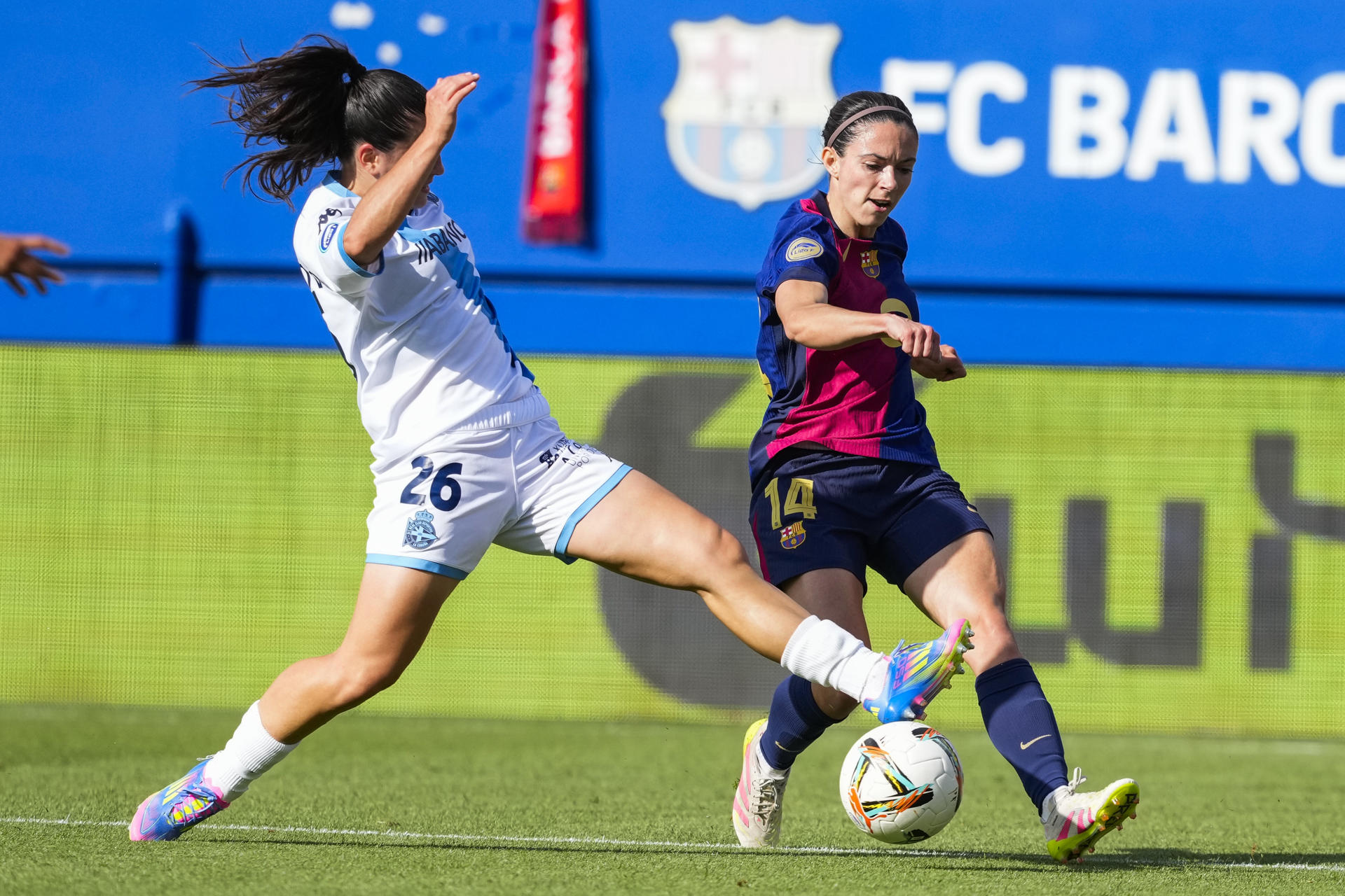 La centrocampista del Barcelona Aitana Bonmatí (d) pelea un balón ante la defensa del Deportivo Paula Novo Saborido (i) este domingo, durante la jornada 28 de la Liga F, entre el FC Barcelona y el RC Deportivo de La Coruña, en el Estadi Johan Cruyff en Sant Joan Despí, provincia de Barcelona. EFE/ Alejandro García