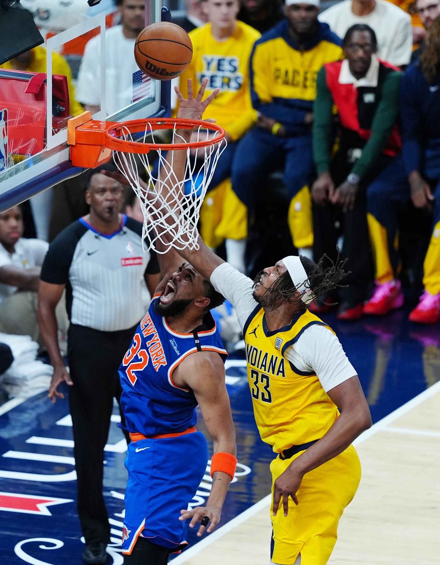 El pívot de los Knicks, Karl Anthony-Towns (i), lanza a canasta ante la marca del pívot de los Pacers, Myles Turner, este domingo durante el tercer partido de las finales de la Conferencia Esteen el Gainbridge Fieldhouse de Indianápolis. EFE/EPA/BRIAN SPURLOCK
