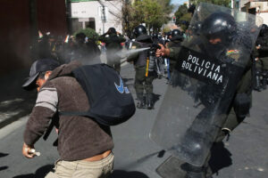 Un integrante de la policía rocía gas a un simpatizante del expresidente de Bolivia Evo Morales (2006-2019) este viernes, durante una marcha para llegar a sede del Tribunal Supremo Electoral (TSE) en La Paz (Bolivia). EFE/ Luis Gandarillas