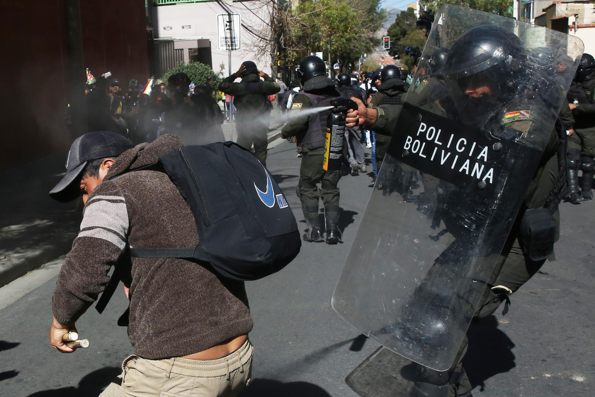 Un integrante de la policía rocía gas a un simpatizante del expresidente de Bolivia Evo Morales (2006-2019) este viernes, durante una marcha para llegar a sede del Tribunal Supremo Electoral (TSE) en La Paz (Bolivia). EFE/ Luis Gandarillas