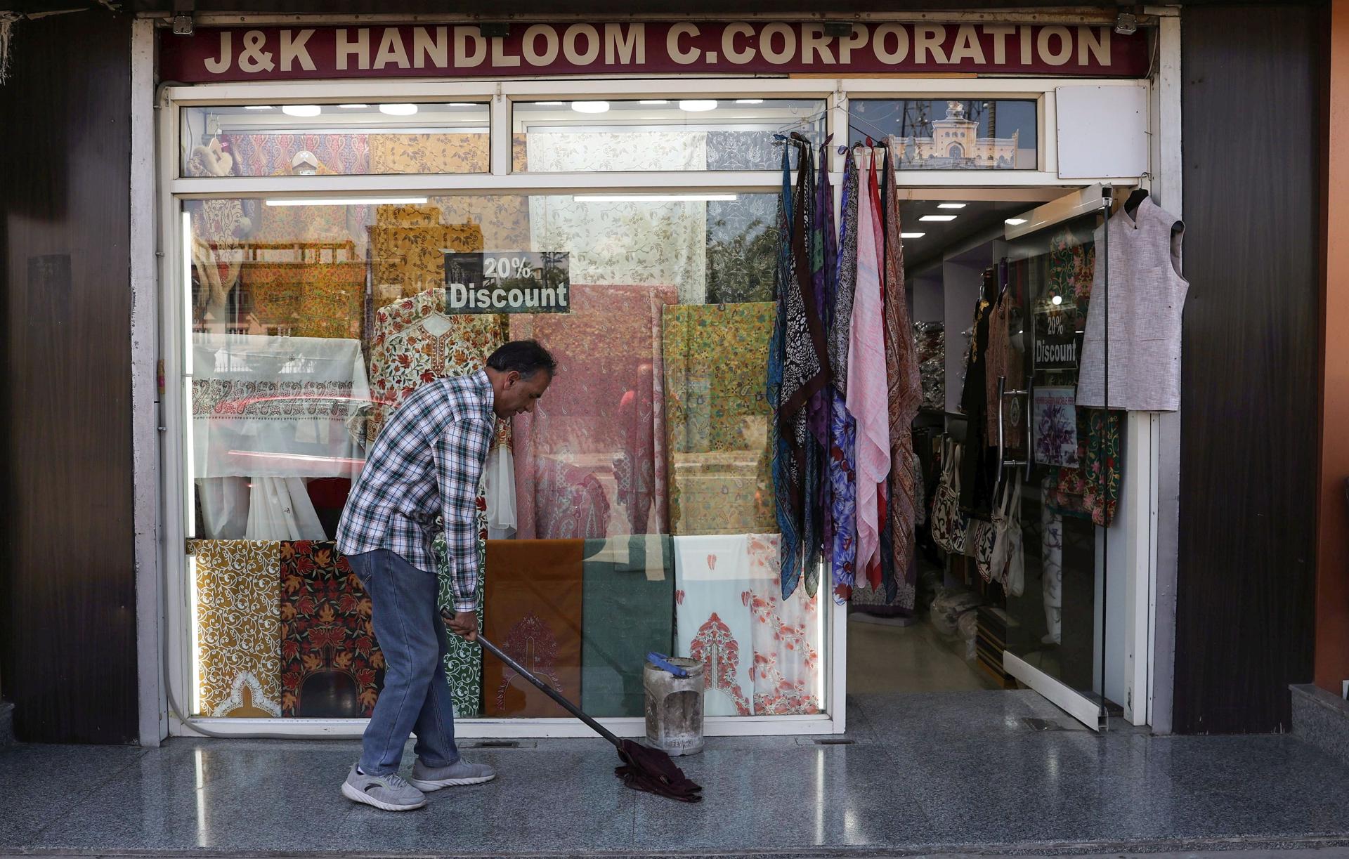 Un hombre limpia la entrada de una tienda en Srinagar, India, el 12 de mayo de 2025. India y Pakistán no reportaron incidentes de disparos durante la noche tras un acuerdo de alto el fuego el 10 de mayo, después de días de escalada militar. EFE/EPA/FAROOQ KHAN