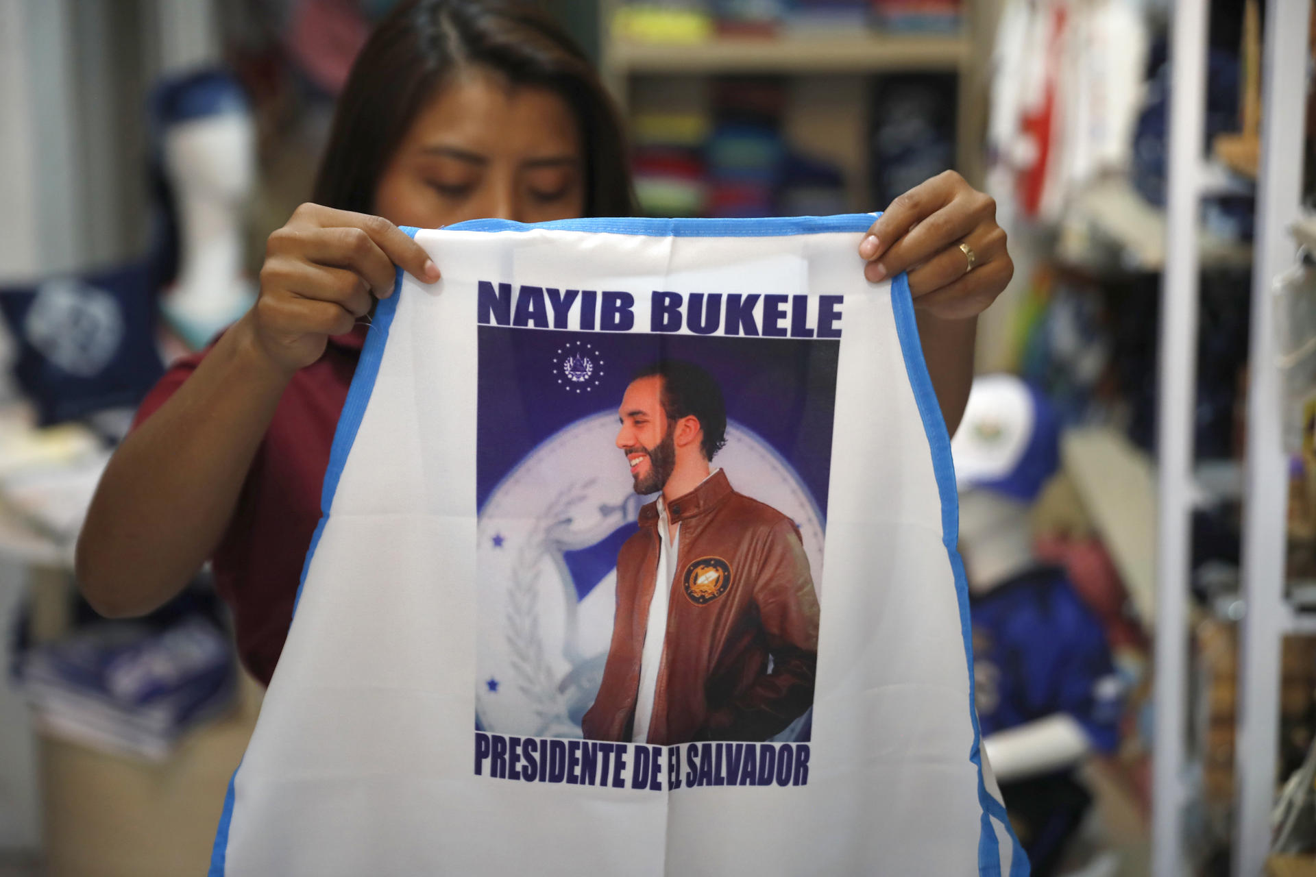 Una mujer muestra un delantal alusivo al presidente salvadoreño, Nayib Bukele, este jueves en una tienda de artesanías en el centro de San Salvador (El Salvador). EFE/Rodrigo Sura
