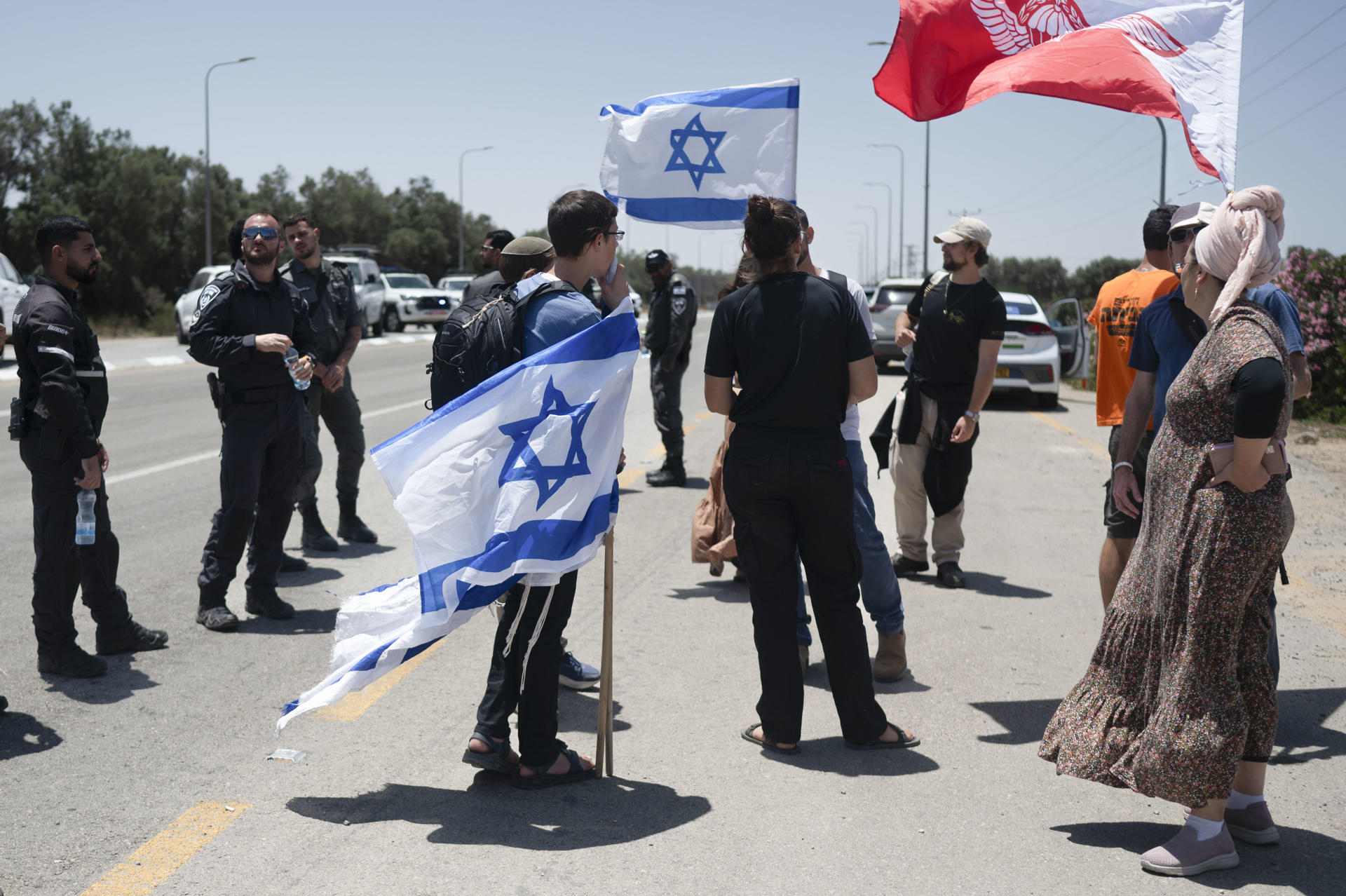Una decena de israelíes simpatizantes de Tsav 9, un grupo de extrema derecha, se congregaron este miércoles a pocos kilómetros del paso de Kerem Shalom, en la frontera con la Franja de Gaza, para protestar contra la entrada de ayuda humanitaria. EFE/ Magda Gibelli