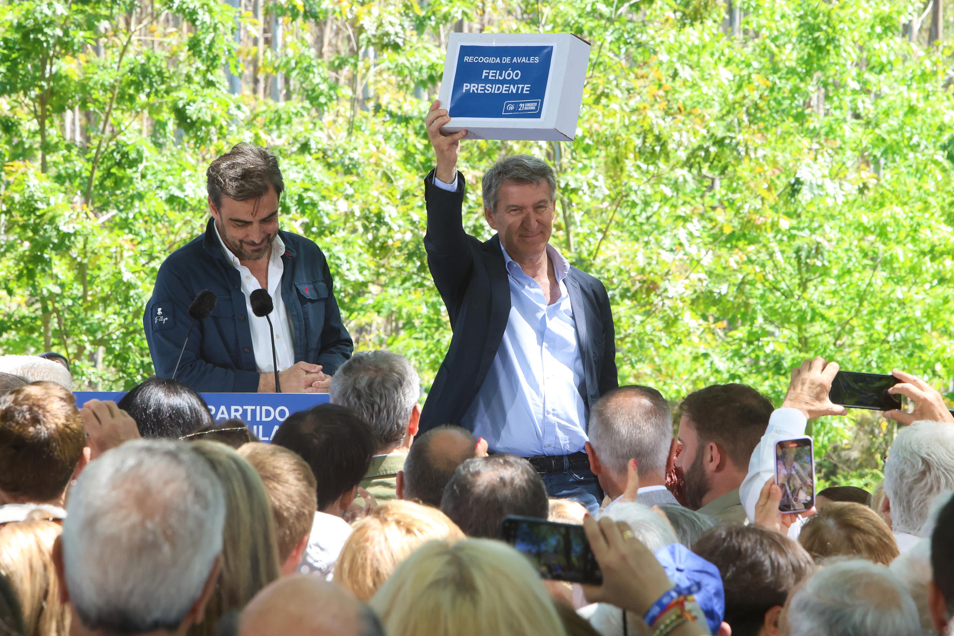 El líder del PP, Alberto Núñez Feijóo (c), recibe parte de los avales de la provincia de A Coruña de manos del líder provincial, Diego Calvo (i), durante la romería popular que se celebra en el municipio coruñés de O Pino, este sábado. EFE/ Xoan Rey