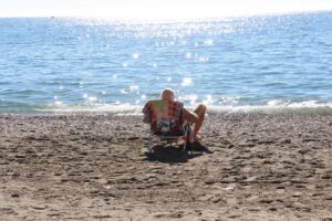 Un hombre toma el sol en la playa y contempla el mar, en una fotografía de archivo. EFE/ Isabel Díaz