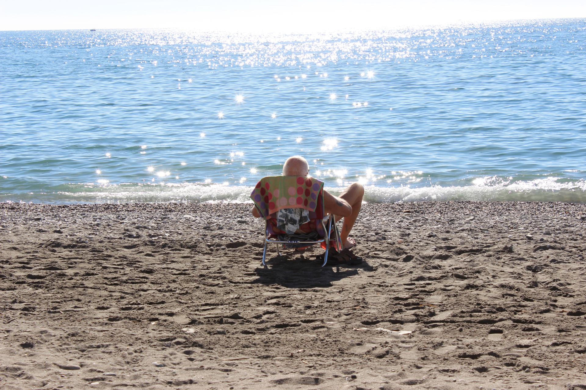 Un hombre toma el sol en la playa y contempla el mar, en una fotografía de archivo. EFE/ Isabel Díaz