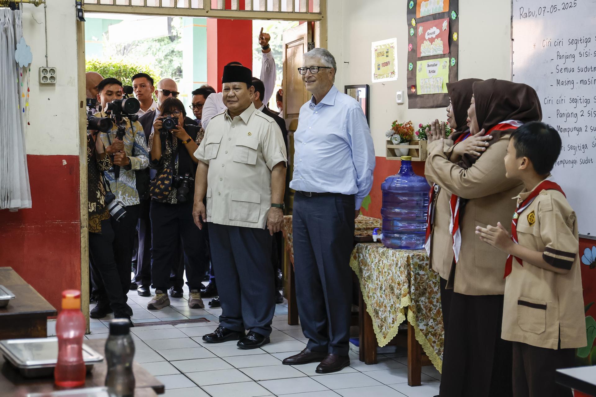 JAKARTA (Indonesia), 07/05/2025.- Microsoft co-founder and former CEO Bill Gates (Center R) accompanied by Indonesian President Prabowo Subianto (Center L) listen to students during their visit to an elementary school in Jakarta, Indonesia, 07 May 2025. Bill Gates is visiting Indonesia to meet the country’s officials supporting the free nutritious meal program policy. EFE/EPA/MAST IRHAM