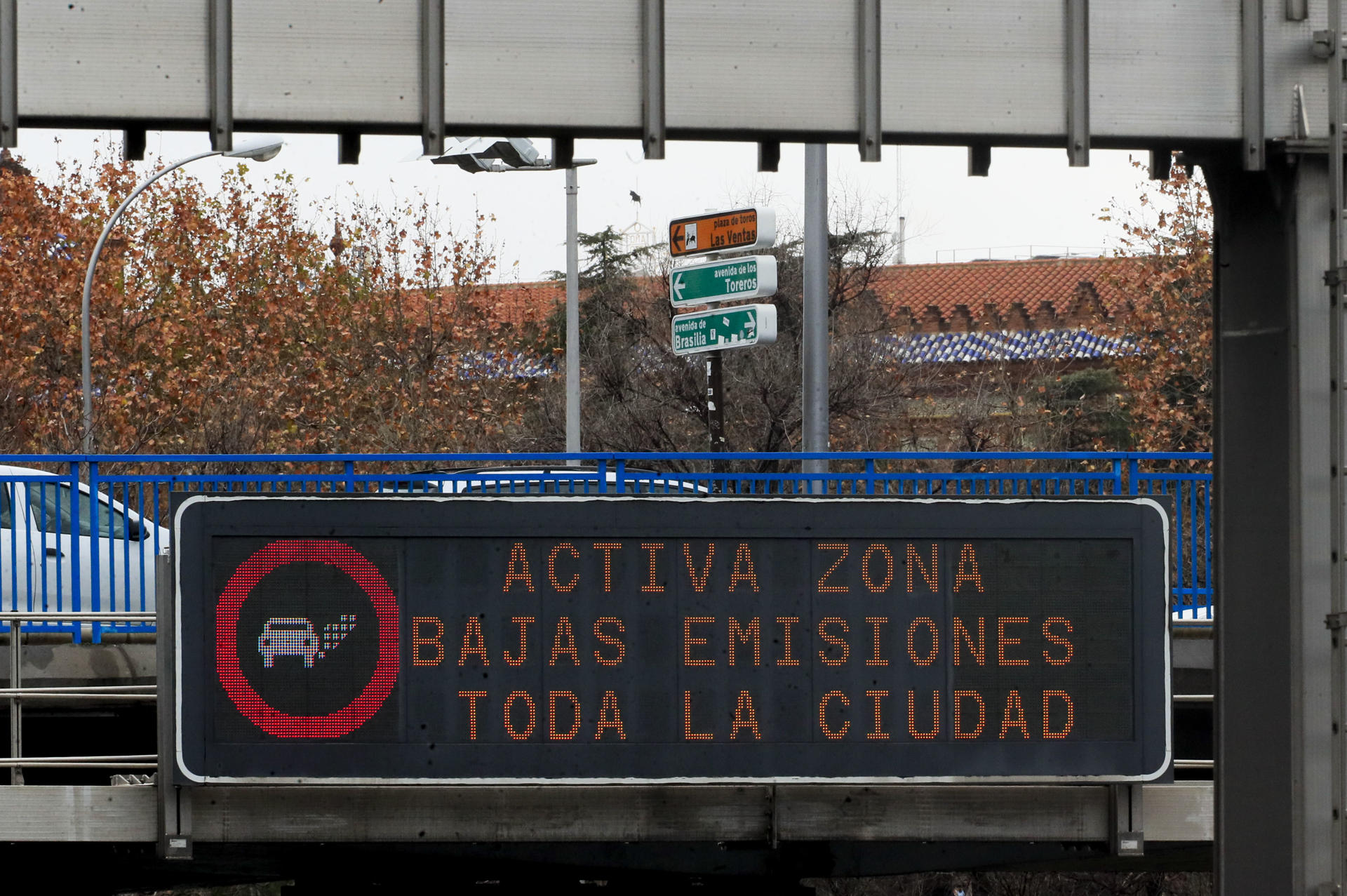 Varios vehículos circulan tras un cartel anunciador sobre la activación de zona de bajas emisiones en Madrid. EFE/ Fernando Alvarado /Archivo