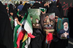 Una mujer muestra unos carteles con la imagen del presidente Ebrahim Raisí, quien falleció el 19 de mayo de 2024 cuando el helicóptero en el que viajaba se estrelló a causa del mal tiempo, durante una congregación en honor del mandatario en Teherán el 15 de mayo. La muerte en un accidente del presidente ultraconservador Ebrahim Raisí hace un año provocó un vuelco político en Irán, donde la llegada al poder del moderado Masud Pezeshkian ha supuesto la relajación de la imposición del velo y un mayor diálogo con Occidente, hasta ahora infructuoso. EFE/ Jaime León