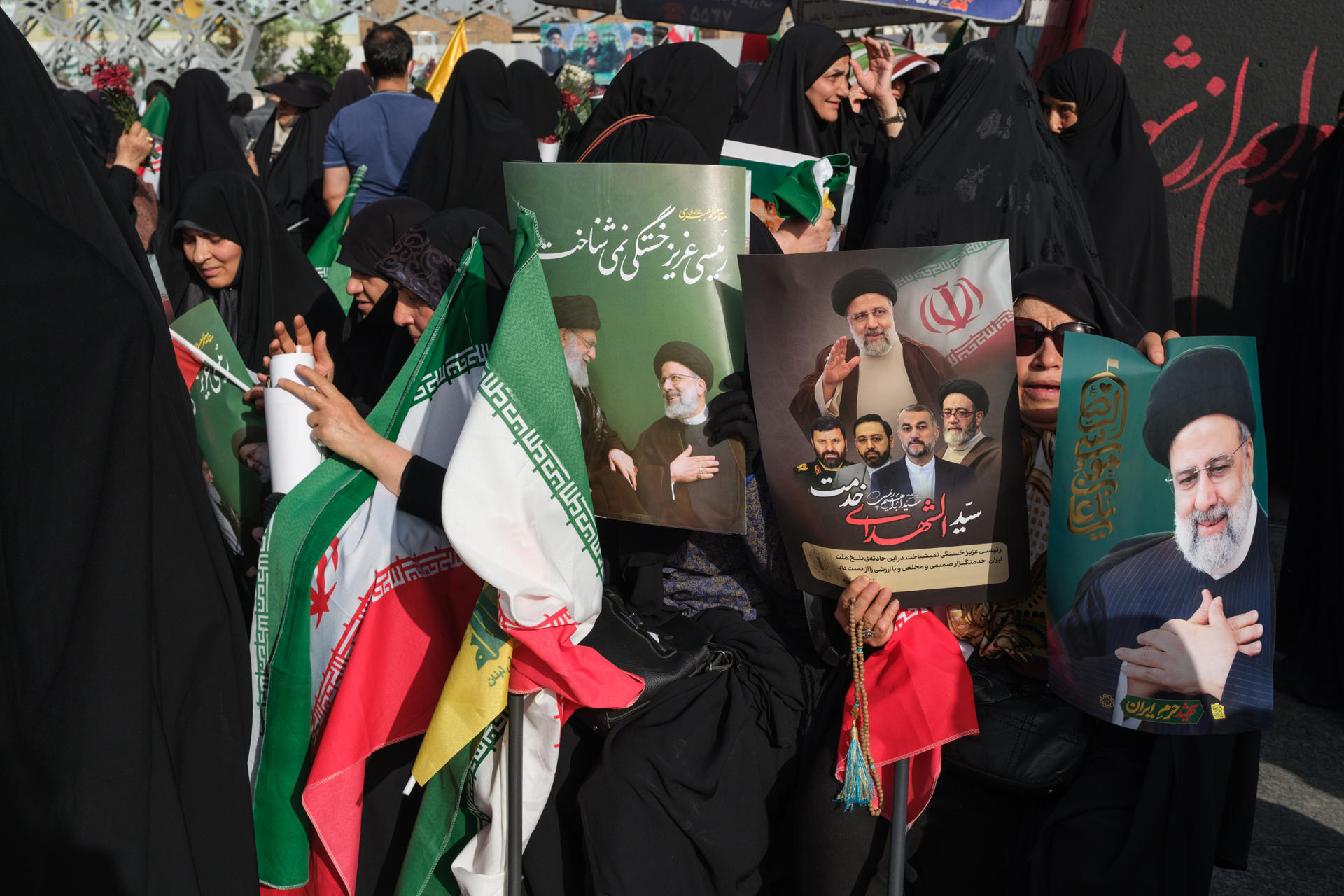 Una mujer muestra unos carteles con la imagen del presidente Ebrahim Raisí, quien falleció el 19 de mayo de 2024 cuando el helicóptero en el que viajaba se estrelló a causa del mal tiempo, durante una congregación en honor del mandatario en Teherán el 15 de mayo. La muerte en un accidente del presidente ultraconservador Ebrahim Raisí hace un año provocó un vuelco político en Irán, donde la llegada al poder del moderado Masud Pezeshkian ha supuesto la relajación de la imposición del velo y un mayor diálogo con Occidente, hasta ahora infructuoso. EFE/ Jaime León