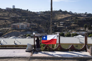 Fotografía de archivo en donde una mujer sostiene una bandera durante la conmemoración del aniversario del megaincendio en Viña del Mar (Chile). EFE/ Adriana Thomasa