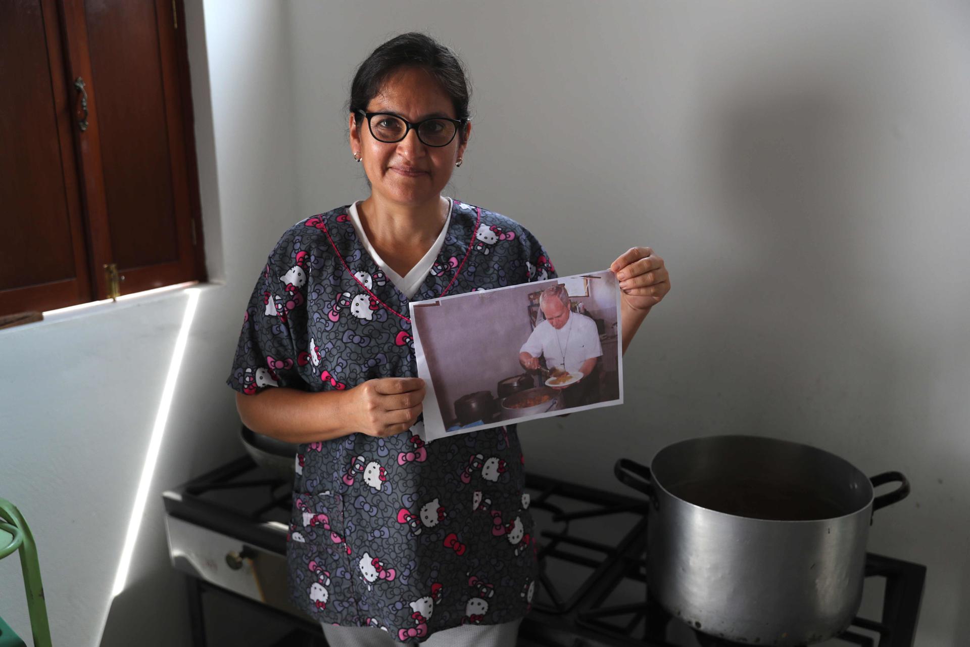 Gaby Ruzasto posa durante una entrevista con EFE en Chiclayo (Perú) y muestra la imagen del papa León XIV sirviéndose concentrado, un plato típico de comida casera peruana. EFE/ Paolo Aguilar