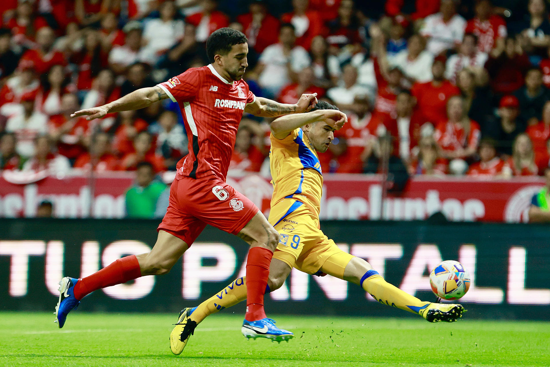 Luan García (i), de Toluca, disputa un balón con Nicolás Ibáñez (d) de Tigres este sábado, en un partido de vuelta de la semifinal del Torneo Clausura 2025 de la Liga MX entre Deportivo Toluca y Club Tigres en el estadio Nemesio Díez en Toluca (México). EFE/ Felipe Gutiérrez