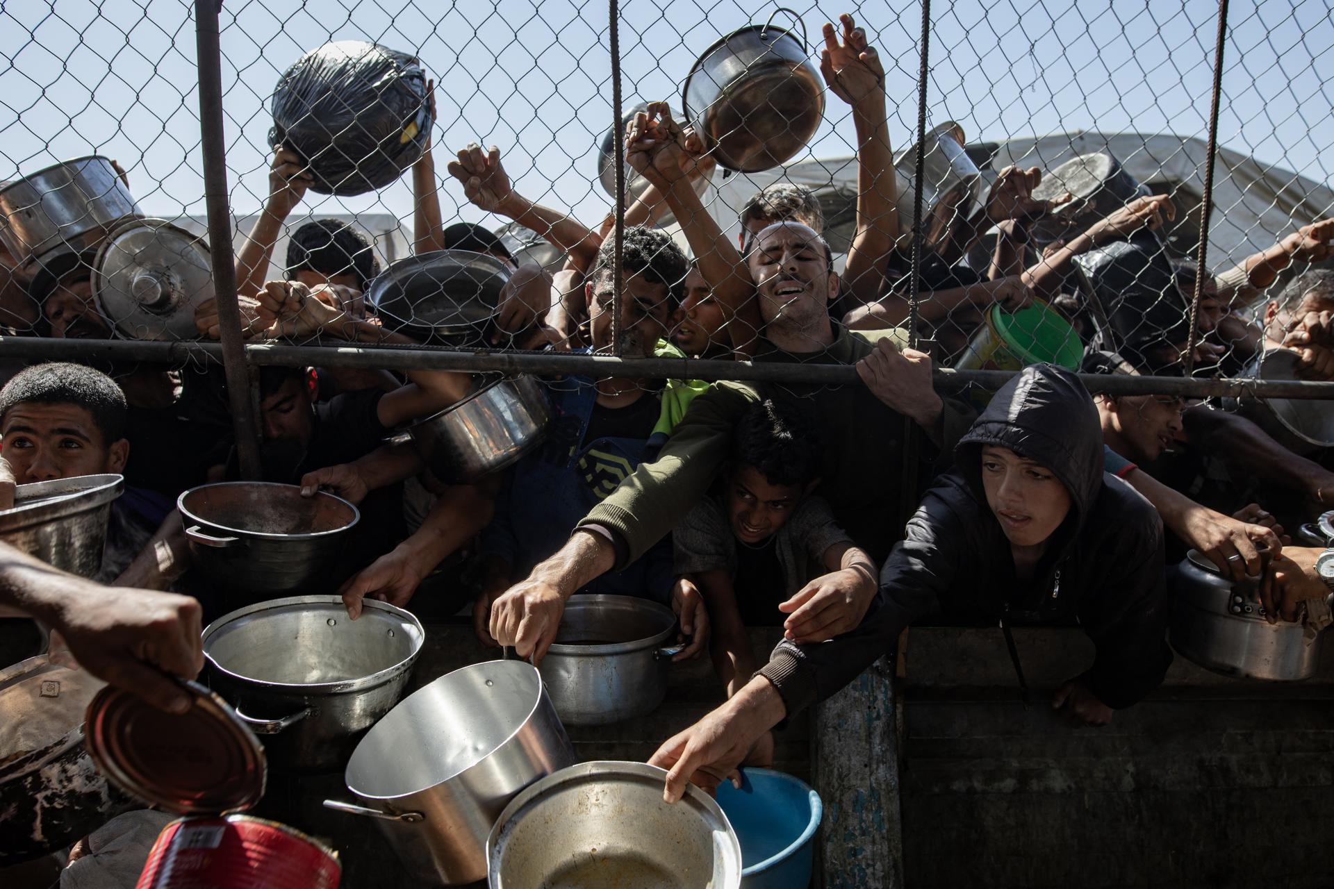 Palestinos desplazados internos se agolpan para recibir raciones de alimentos en Jan Yunis, sur de la Franja de Gaza, 30 de mayo de 2025. EFE/EPA/HAITHAM IMAD
