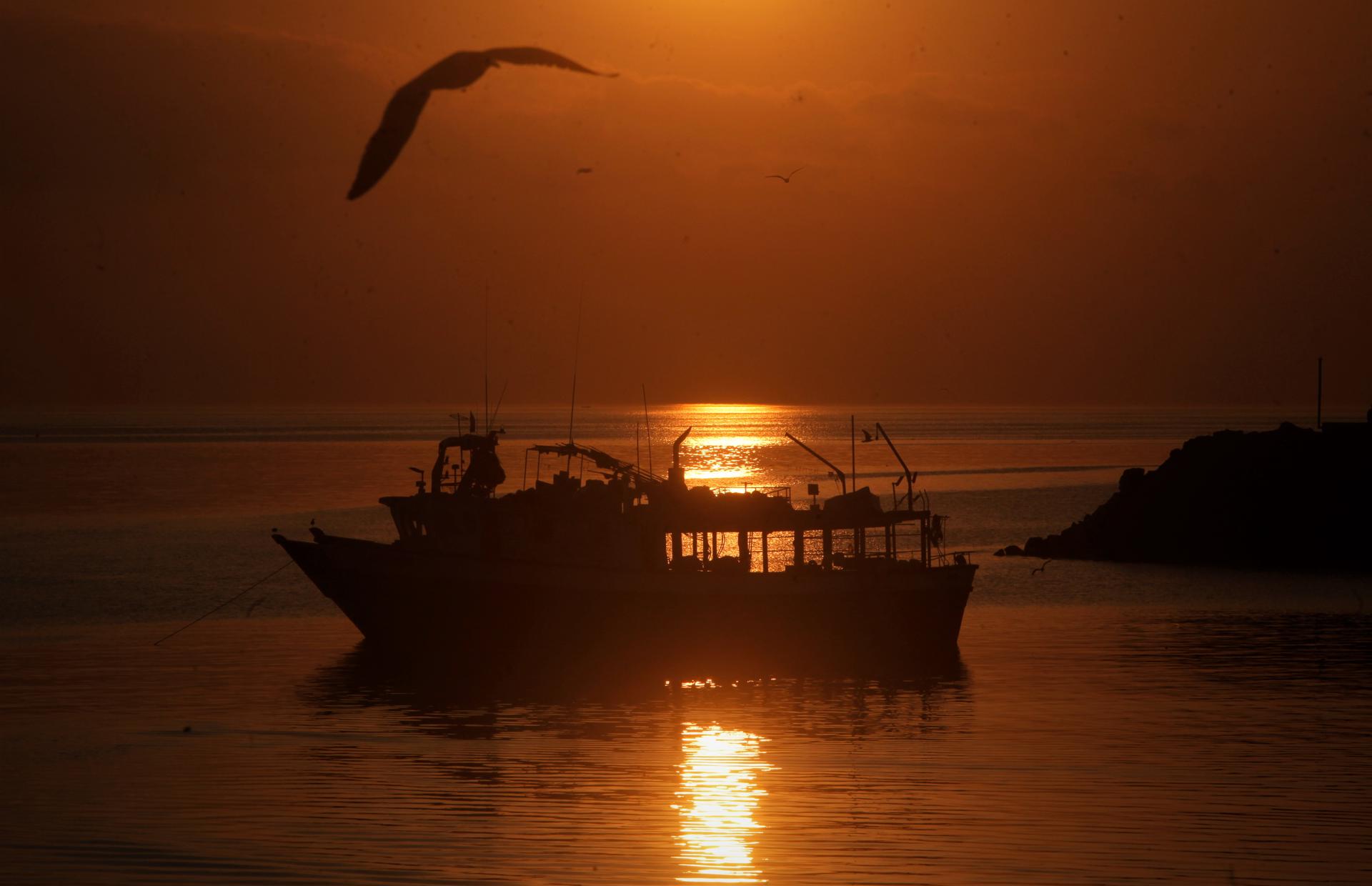 Imagen de archivo de un bote pesquero al amanecer. EFE/ Carlos Lemos